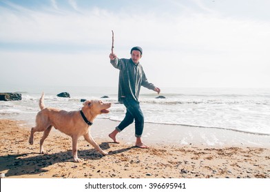 man walking with labrador dog on beach