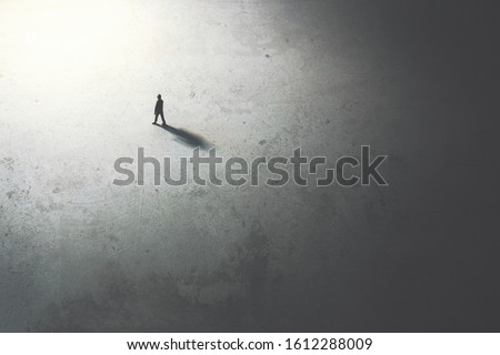 man walking in the night toward the light