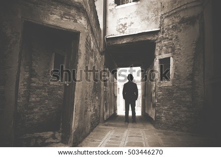 Man walking in a old mystic dark alley