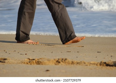 Man Walking On Beach Footprints