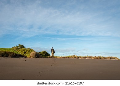 Man Walking On The Beach, Leaving Footprints On The Sand, New Plymouth.