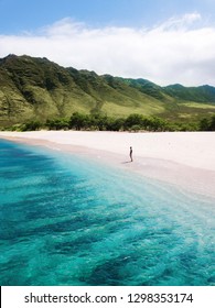 Man walking on the beach - Tropical paradise beach with white sand and mountain background travel tourism wide panorama background. Hawaiian beach. Oahu. 