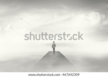Man walking on a boardwalk in the fog