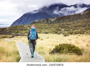 Man walking on hike trail route with Mount Cook National Park, beautiful mountains region. Tramping, hiking, travel in New Zealand. - Shutterstock ID 2103710876