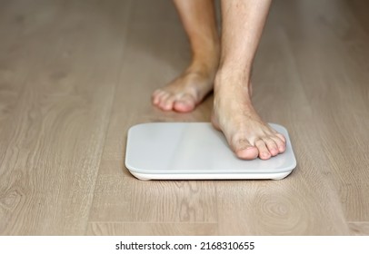 Man Walking On Scales Measure Weight. Male Wal Checking BMI Weight Loss. Human Barefoot Measuring Body Fat Overweight. Guy Legs Step On Bathroom Scale.