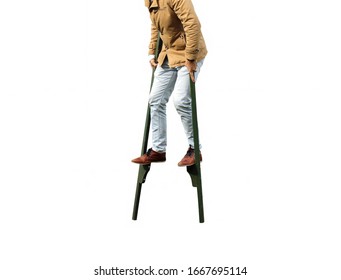 Man Walking On Stilts Isolated On White