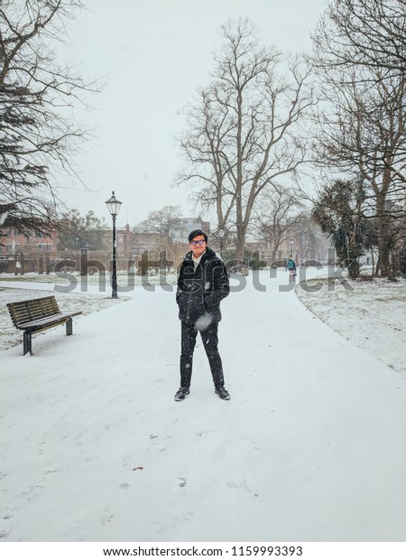 Man walking on the street covered with snow.Man\
walking outdoor during\
winter.