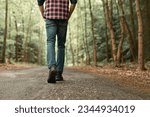 Man walking on sunlit trail in autumn forest enjoying peaceful walk in nature 