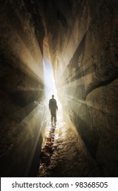 Man Walking Out Of A Cave