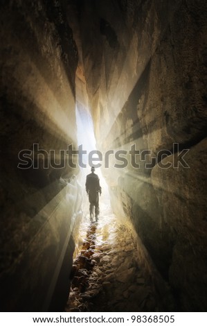 man walking out of a cave