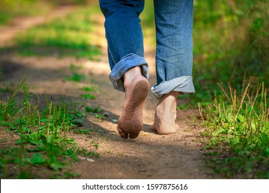 Man walking in park. Close-up of bare feet soiled with ground. healthy lifestyle.