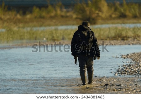 Man walking in a stream. looking for precious stones in water.