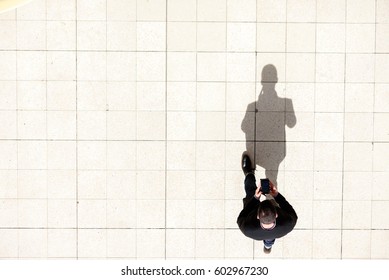 Man Walking And Texting On His Mobile Phone Shot From Above