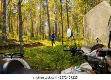 Man walking through a forest while exploring nature and Quadbike or ATV in sunny forest