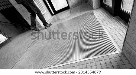 Man walking towards exit in industrial building. Photo in Black and white.