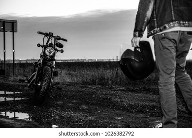 A man walking towards his motorcycle on an empty coastal road in Long Island, New York.