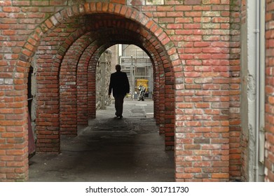 man walks in a brick tunnel - Powered by Shutterstock