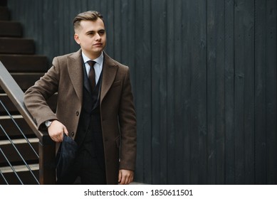 A man walks at city street in the image of an English retro gangster of the 1920s dressed in Peaky blinders style.