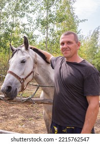 A Man Walks With A Horse On A Warm Summer Day. 