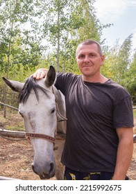 A Man Walks With A Horse On A Warm Summer Day. 