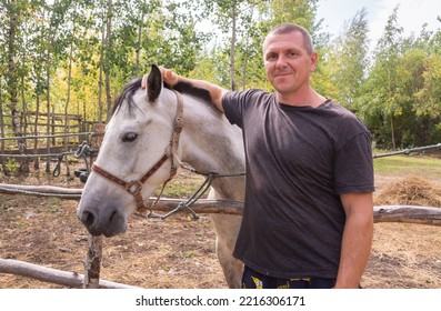 A Man Walks With A Horse On A Warm Summer Day. 