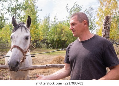 A Man Walks With A Horse On A Warm Summer Day. 