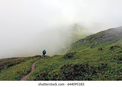 A man walks through a cloud in the mountains