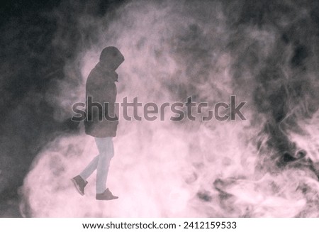 A man walks through a smoke screen
