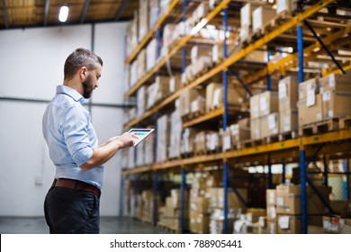 Man warehouse worker with a tablet.