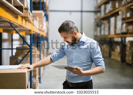 Man warehouse worker with a tablet.