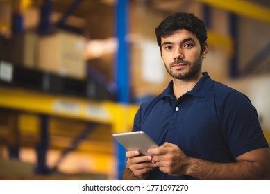 Man Warehouse Worker Using Tablet To Check And Control With Modern Trade Warehouse Logistics Business, Holding Digital Tablet Standing In Aisle With Goods