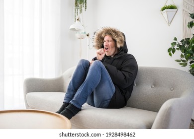 A Man With Warm Clothing Feeling The Cold Inside House On The Sofa