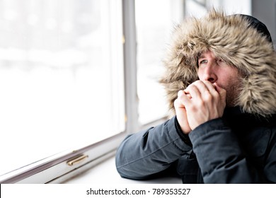 Man With Warm Clothing Feeling The Cold Inside House Close To A Window