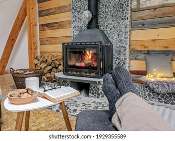 A man in warm wool socks sitting comfortably indoors relaxing at the fireplace on a winter evening