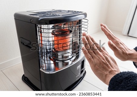 A man warms himself with an oil stove.
Translation:Low odor, extinguishing position, electronic ignition