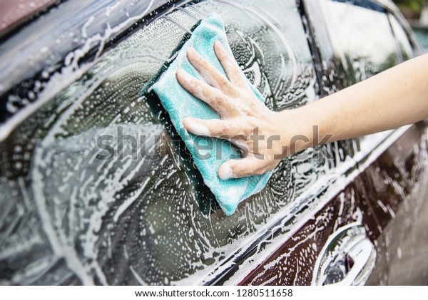 Man wash car using shampoo - every day life car
care concept