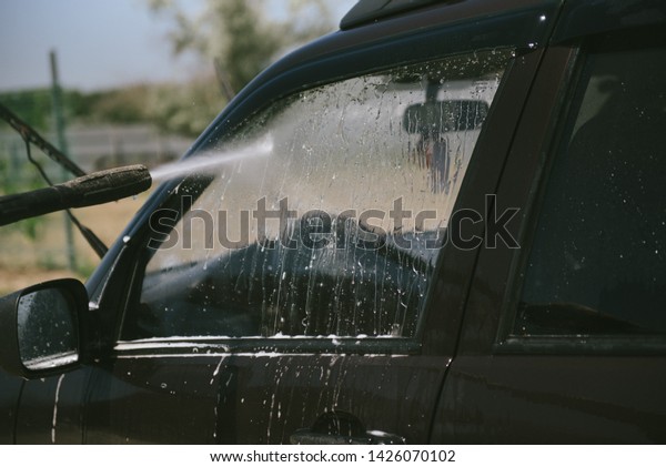 A man washes a car\
with a high pressure washer. A man washes a car. A car washer with\
high pressure washer