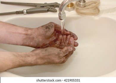 man washes hands dirty after working as a plumber