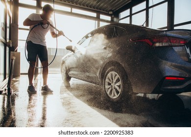 Premium Photo  Worker washing car with active foam on a car wash.