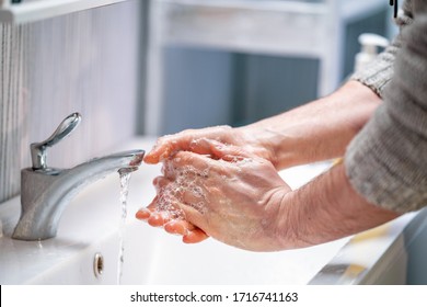 man washes his hands with soap at home. concept virus protection. hand hygiene. - Shutterstock ID 1716741163