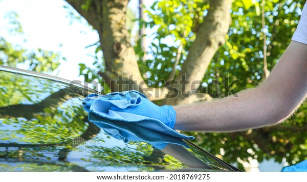 A man washes the\
rear window of the car