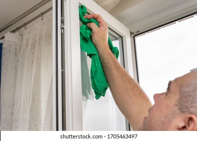 A Man Washes A Window In An Apartment. House Cleaning