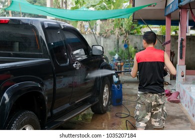 Man Washing Black Pickup Truck Car With High Pressure Washer 