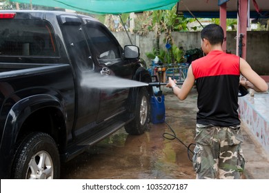 Man Washing Black Pickup Truck Car With High Pressure Washer 