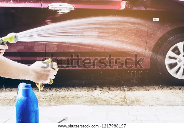 Man washing car using shampoo and water - home\
people car clean concept