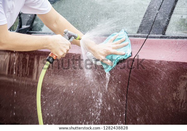Man washing car using spray jet water - home\
people car clean concept