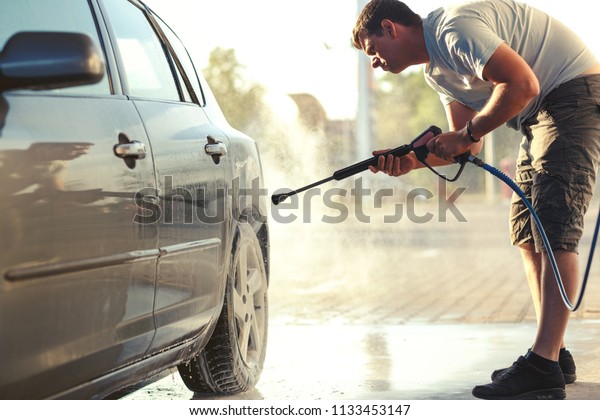 Man washing car wheel. Car cleaning with\
water jet. Car rim wash close up close\
up\
