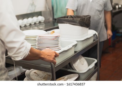 Man washing dish on sink at restaurant - Shutterstock ID 1617436837