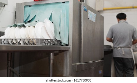 Man Washing Dish On Sink At Restaurant