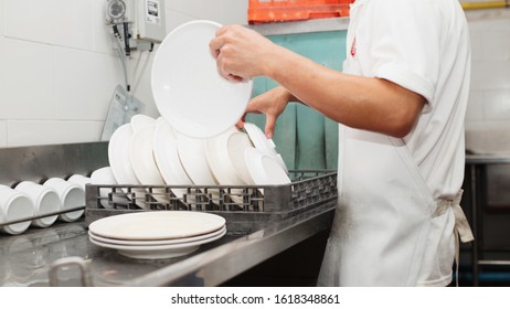 Man Washing Dish On Sink At Restaurant